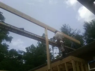 Carpenter setting a ridge beam over a new addition frame — Ice Dam Removal by Roofing Brothers in White Marsh