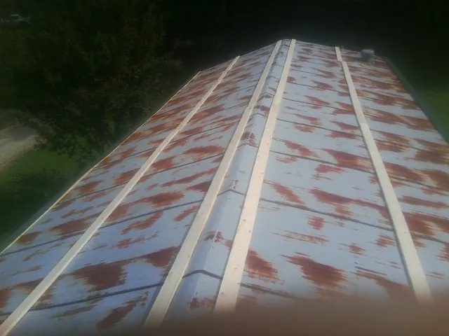 Rusted metal roof panels with new wood purlins before replacement — Storm Damage Roof Repair in White Marsh by Roofing Brothers