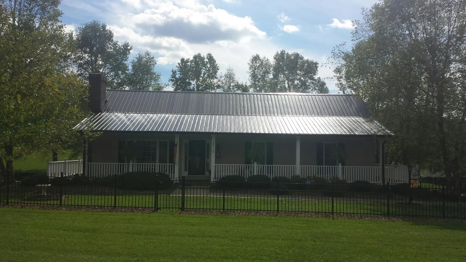 Gray metal roof on a brick ranch with a full width front porch — Gutter Guard Installation work by our crew in White Marsh