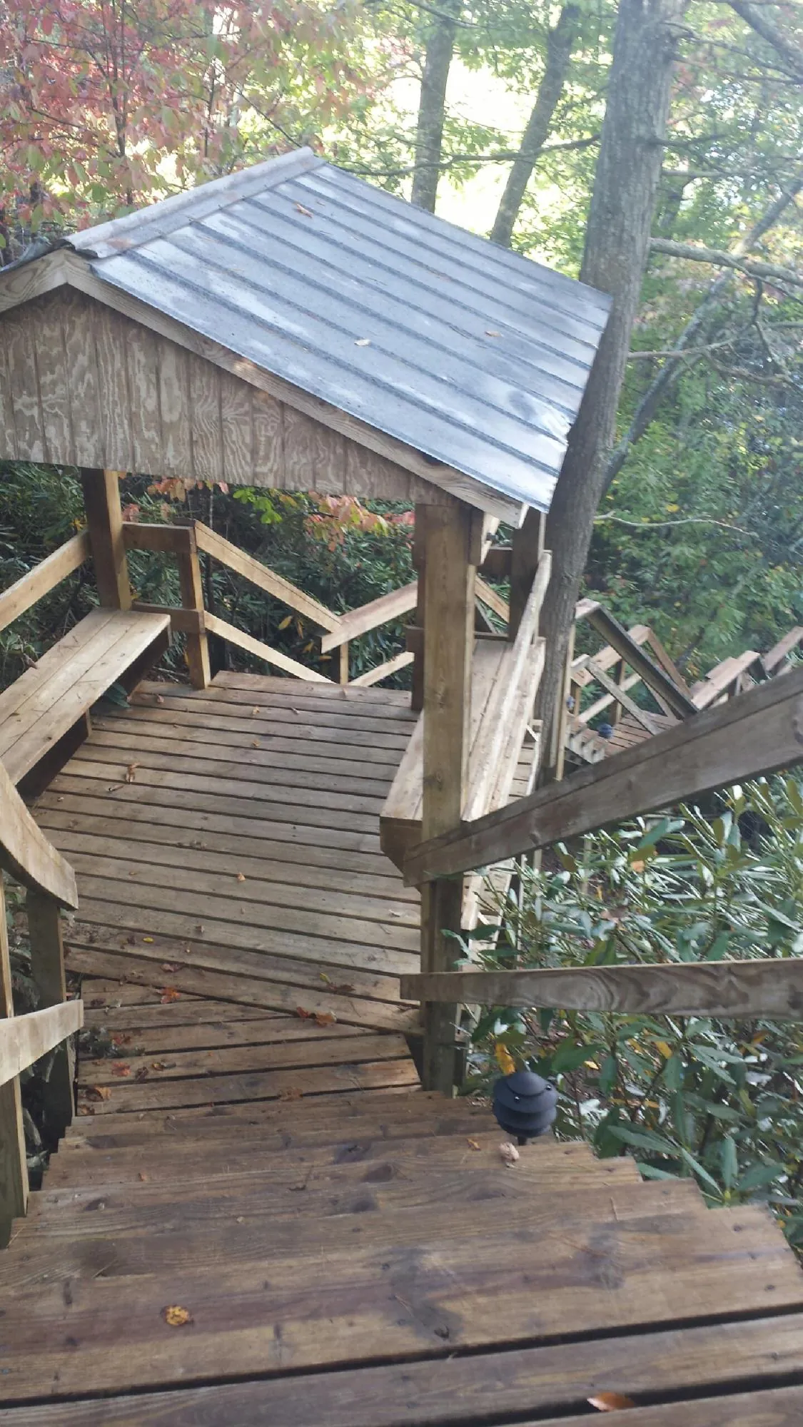 Metal roofed shelter over wooden steps on a wooded walkway — Skylight Repair & Installation work by our crew in White Marsh